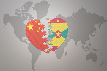 puzzle heart with the national flag of china and grenada on a world map background. Concept.