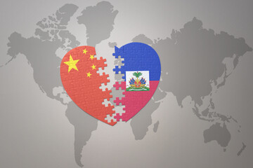 puzzle heart with the national flag of china and haiti on a world map background. Concept.
