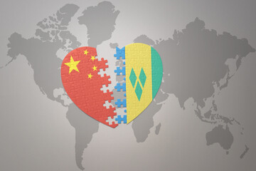 puzzle heart with the national flag of china and saint vincent and the grenadines on a world map background. Concept.