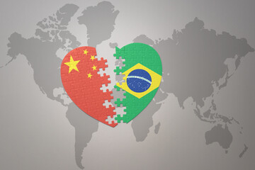 puzzle heart with the national flag of china and brazil on a world map background. Concept.