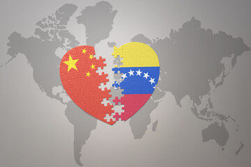 puzzle heart with the national flag of china and venezuela on a world map background. Concept.