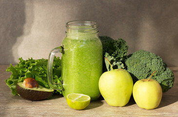Diet green smoothie in a glass jar of fruits and vegetables: avocado, apple, broccoli, lime. Sunny day