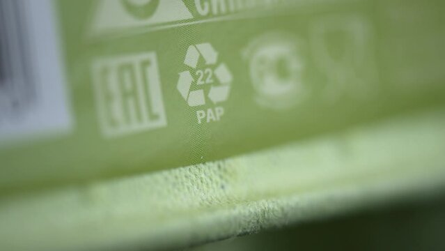 4k Closeup view of 22 PAP recycling sign or label and others on green packaging spbd. These are paper and cardboard, boxes of household appliances, groceries, cosmetics, postcards, book covers