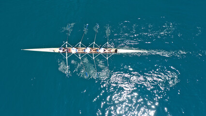 Aerial drone top down photo of sport canoe operated by team of young women in emerald sea waters © aerial-drone