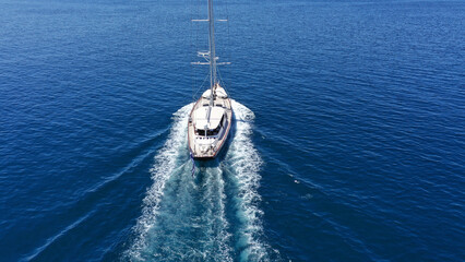 Aerial drone birds eye view photo of beautiful sailboat with blue sails cruising in the deep blue...