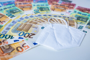 Corona face mask with a bundle of Euro banknotes