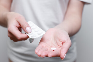 the woman squeezes the pill into her hand. close-up. medications for the disease