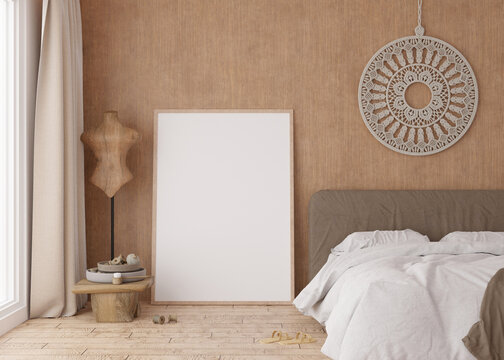 Empty vertical picture frame standing on parquet floor in modern bedroom. Mock up interior in boho style. Free space for picture or poster. Bed, macrame. 3D rendering.