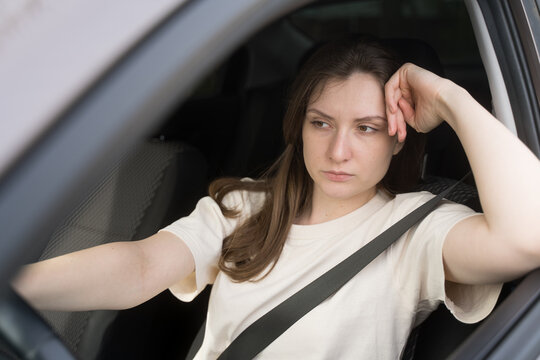Depressed woman behind the wheel of a car. Frustration and sadness