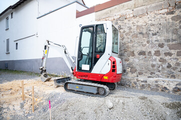Fototapeta na wymiar a mini excavator stands on a construction site of a single family house construction