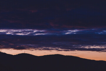 purple and orange sunset over the mountains with eucalyptus gum trees silhouettes shot in Tasmania
