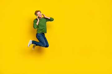 Fototapeta na wymiar Full length photo of cool dreamy guy dressed sweater earphones enjoying music empty space isolated yellow color background