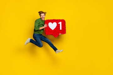 Full length photo of funny cool guy dressed sweater jumping holding heart pinata empty space...