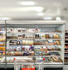 choosing a dairy products at supermarket.empty grocery cart in an empty supermarket