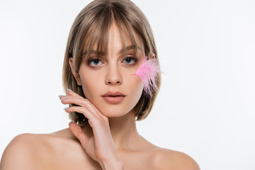 Naklejka premium sensual young woman with bare shoulders and pink feather on face isolated on white