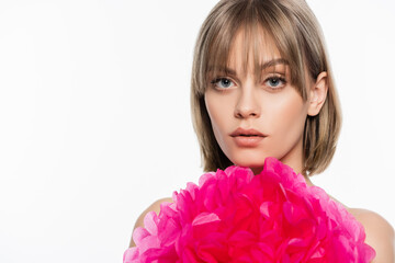 young woman with bangs near pink decorative flower isolated on white