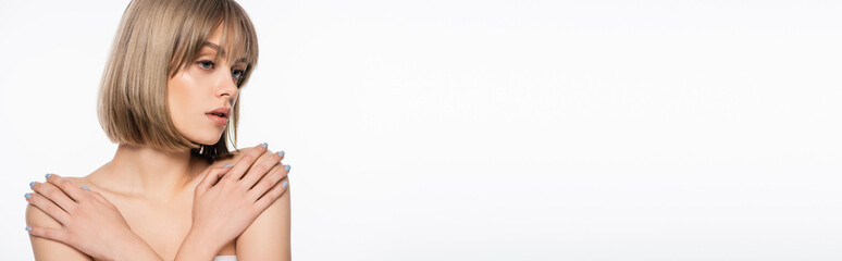 Fototapeta premium young woman touching bare shoulders and looking away isolated on white, banner