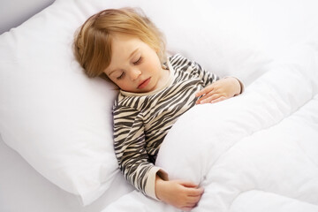 Sweet caucasian blonde adorable cute baby girl, toddler, sleeping in bed on white sheets, under warm blanket.Infant, child, kid having rest, nap,Quiet sleep, dream concept