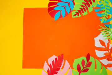 orange paper on a yellow background surrounded by leaves, creative tropical design, copy space, vocation time