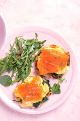 Smoked salmon with scrambled eggs and spinach on a toasted English muffin.