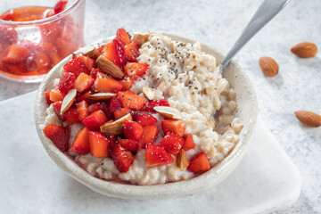 Oatmeal porridge with strawberries top view. Porridge oats in bowl. Healthy food breakfast