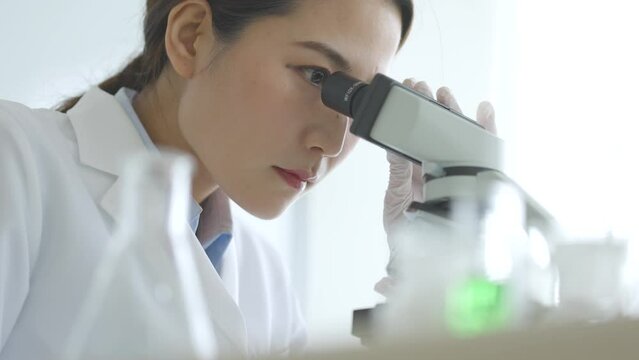 顕微鏡を覗く研究者の女性