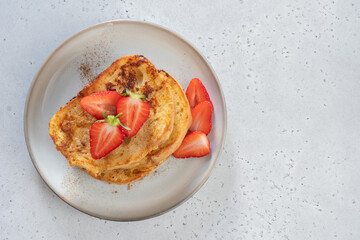 French toast with strawberries, maple syrup and sugar for breakfast