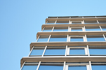 Part of the building with plastic windows against the sky.