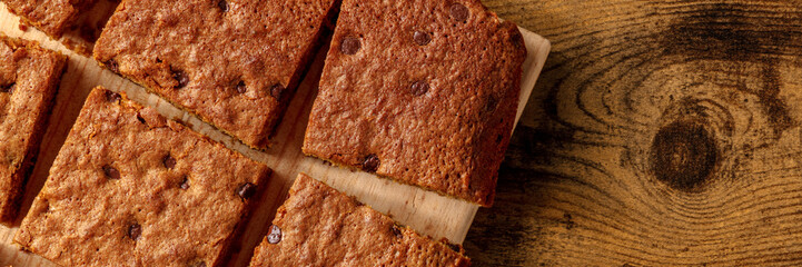 Blondie brownie dessert bars with chocolate chips panorama, shot from the top with a place for text...