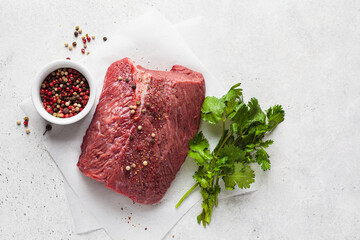 Whole piece of raw beef on gray background, top view, copy space.