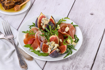 Appetizer arugula with Parma ham and fresh figs stuffed blue cheese, honey