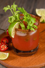 Michelada the Mexican Bloody Mary. Made with tequila, spicy sauce, served over ice in a glass of celery with a peppery rim, garnished with a stalk of celery and a wedge of lime. Drinks and cocktails w