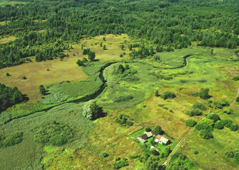 River in rural. Aerial view of river near countruside at forest. Drone view of the russian village with old houses. House in Wildlife . European Green Nature Scenery. Wetland, marsh and bog.