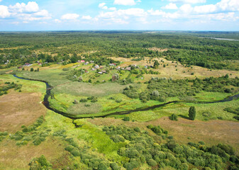 Fototapeta na wymiar River in rural. Aerial view of river near countruside at forest. Drone view of the russian village with old houses. House in Wildlife . European Green Nature Scenery. Wetland, marsh and bog.