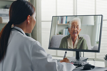 Female Asian doctor making video call with Asian senior woman grey hair 80-90s, telemedicine...