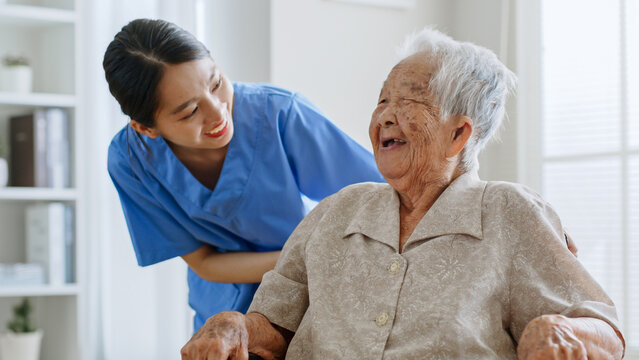 Young Asian woman, nurse, caregiver, carer of nursing home talking with senior Asian woman feeling happy at home