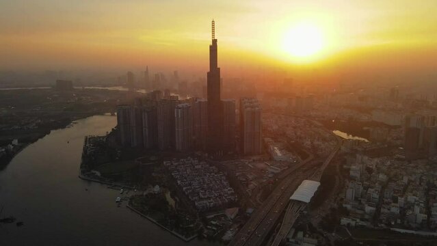Aerial Drone in 4k over Ho Chi Minh City, Saigon Skyline, Vietnam. Sunset with Landmark 81 and Saigon river.