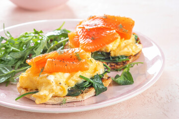 Smoked salmon with scrambled eggs and spinach on a toasted English muffin.