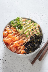 Hawaiian Salmon Poke Bowl with avocado, cucumber , rice and sesame seeds. Sushi bowl. Organic and healthy food.
