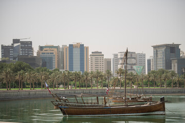 Fototapeta na wymiar Doha,Qatar- April 24,2022 Traditional boats called Dhows are anchored in the port near the Museum of Islamic Art Park.