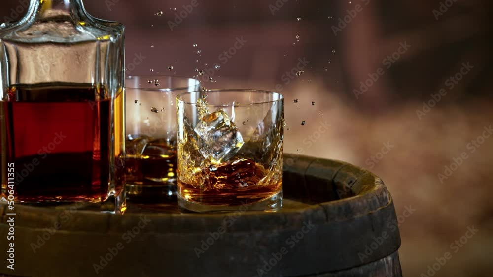 Poster Super slow motion of falling ice cube into whiskey. Speed ramp effect. Filmed on high speed cinema camera, 1000fps.