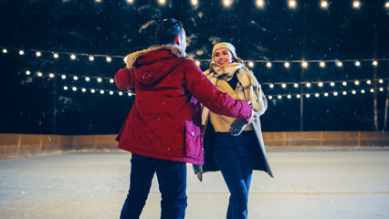 Romantic Winter Snowy Evening: Ice Skating Couple Having Fun, Step on Ice Rink and Start Dancing,...