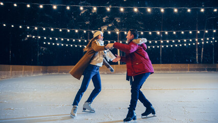 Romantic Winter Snowy Evening: Ice Skating Couple Having Fun, Step on Ice Rink and Start Dancing,...