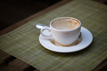 Empty coffee cup with stains of milk froth on the edges leaved on street cafe table