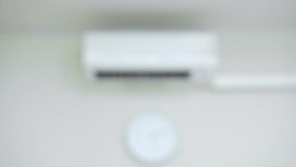 Closeup hand adjust temperature of air conditioner at 25 degree C via remote control. Save energy concept