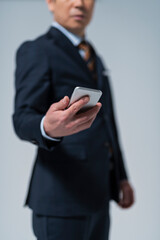 スマートフォンを持った60代ビジネスマン