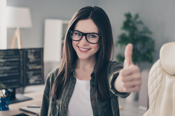 Portrait of beautiful cheerful girl nerd geek giving thumbup advert web development company at workplace workstation indoors
