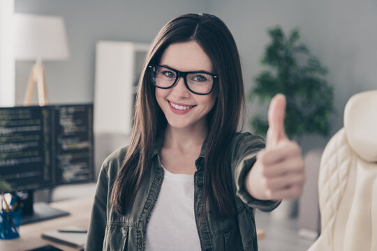 Portrait of beautiful cheerful girl nerd geek giving thumbup advert web development company at workplace workstation indoors