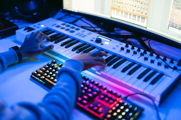 Producer, audio engineer uses a control panel and screen to record a track of a new album in a recording studio. Image producer, designer in working process