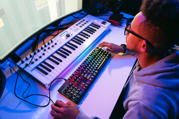 Producer, audio engineer uses a control panel and screen to record a track of a new album in a recording studio, in a soundproof room. Image producer, designer in working process